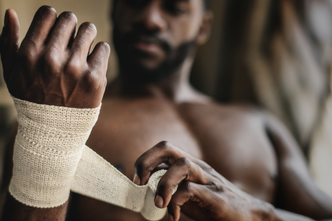 man wrapping bandage around wrist