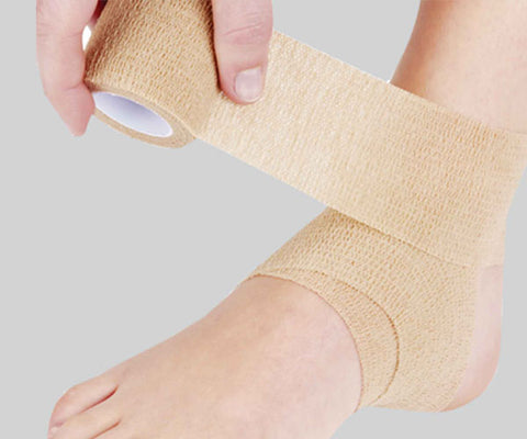 man wrapping bandage around ankle