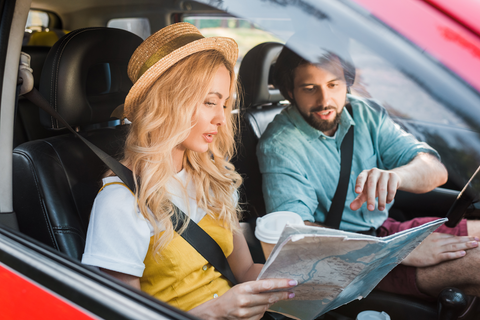 man and woman in car looking at map