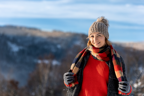 woman with winter wear holding multi color scarf