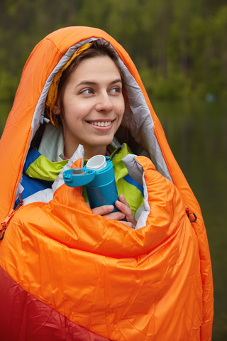 woman wrapped around in orange sleeping bag