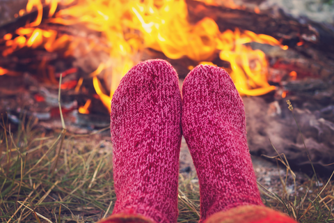 warming with pink socks warming feet at campfire