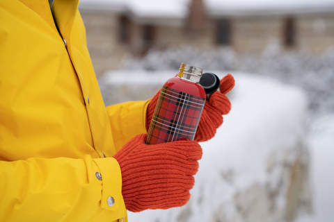 hands with red gloves holding red thermostat