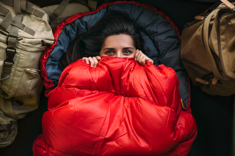 happy woman comfortable in red sleeping bag