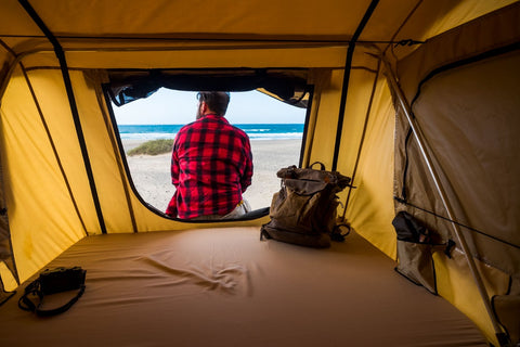 man at the edge of a yellow tent