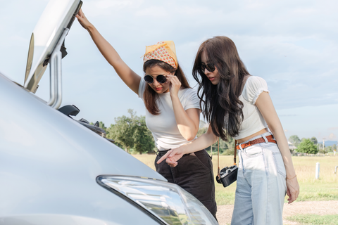 young asian women's car broken down at the side of the road