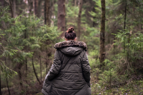 woman walking in forest with warm coat