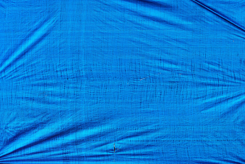 A piece of bright blue waterproof tarpaulin used for making a tent