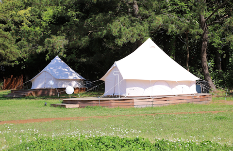 A white bell tent has a spherical shape that creates an enclosed area