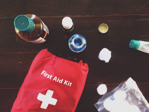 A first aid bag with items on a wooden table