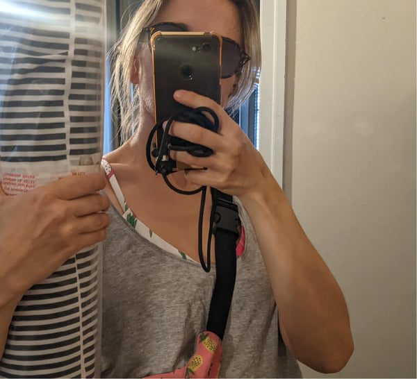 woman taking a selfie in a mirror holding a roll of striped fabric.