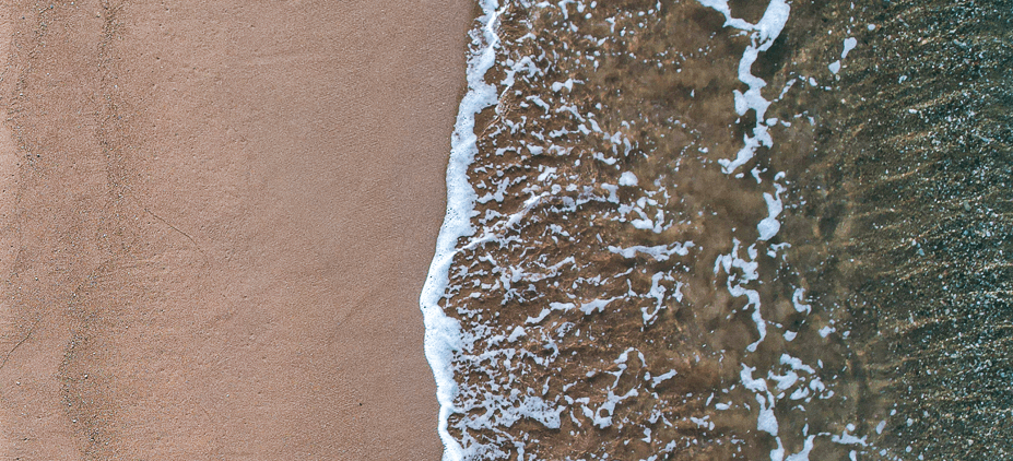 birds-eye view of a beach with water on the shore