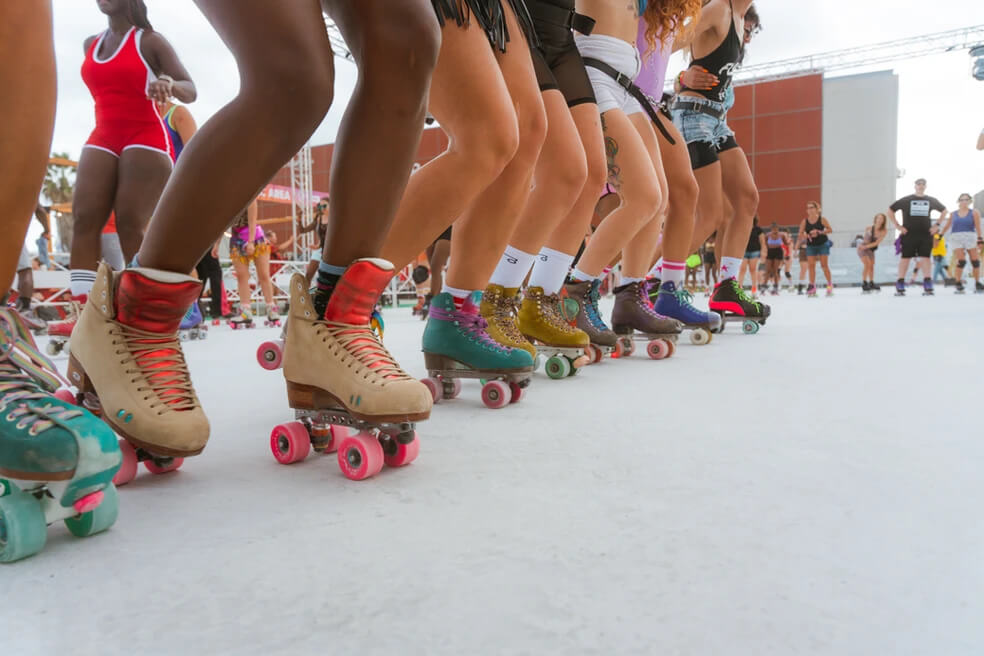 Row of women roller skaters, zoomed in at their skates.