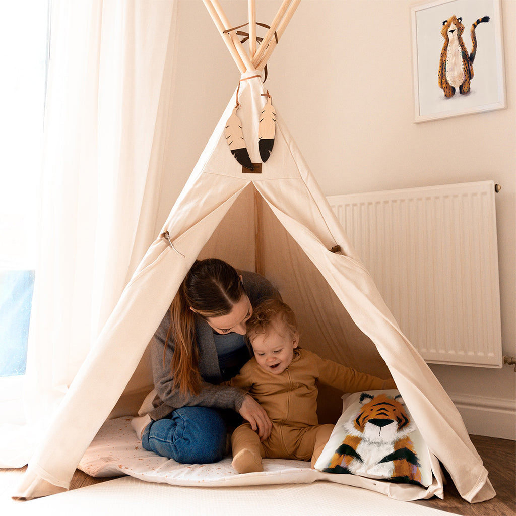 Mum and child in kid's teepee with a tiger cushion