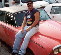 Gary Halbert sitting on a car