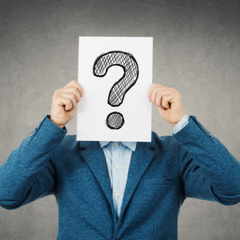 man holding question mark in front of face