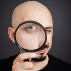 Man looking through magnifying glass