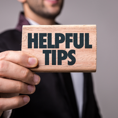 Man holding sign that says "helpful tips"