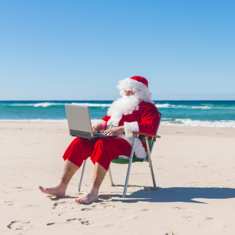 santa typing on laptop at beach