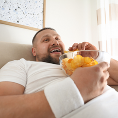 Man eating chips on couch