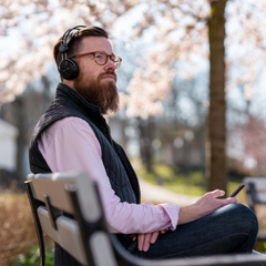 man listening to podcast in park
