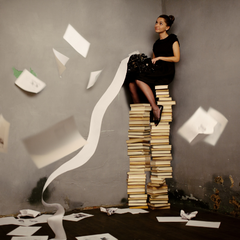 Woman sitting on top of books