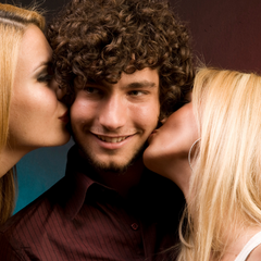 popular guy with two women kissing face