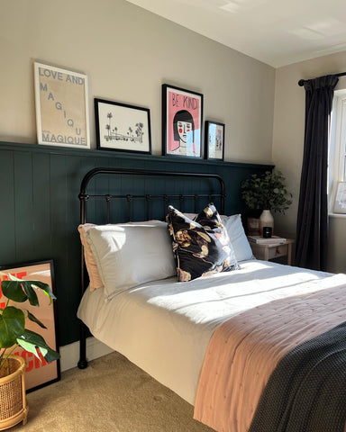 Bedroom with shiplap wall panelling and prints 