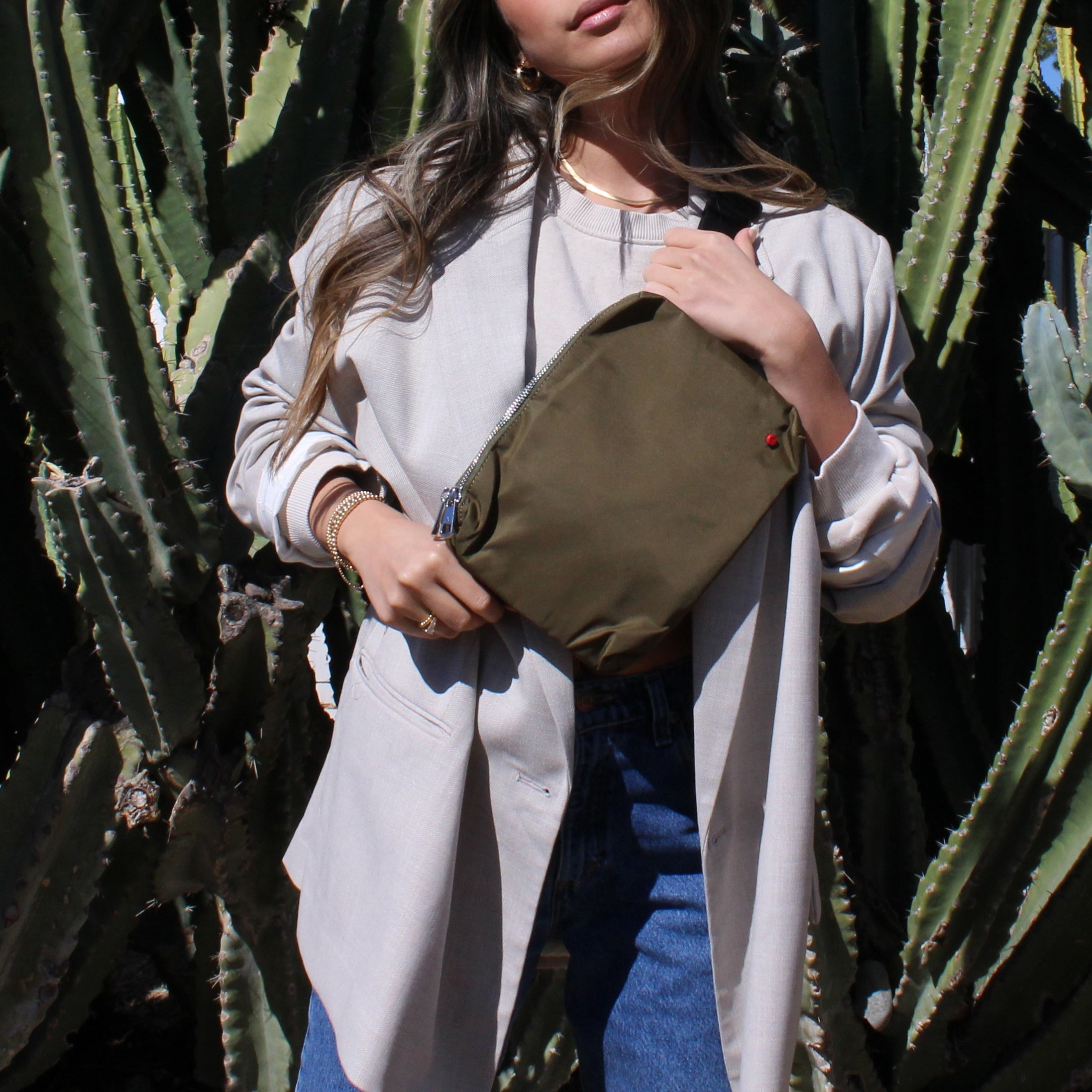 young woman wearing STATE Bags lorimer fanny pack in olive across her chest 