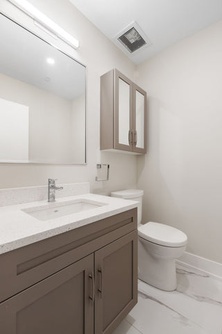 A single sink bathroom vanity with painted, shaker-style cabinet doors