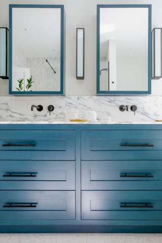 A double bathroom vanity with trendy blue cabinets.