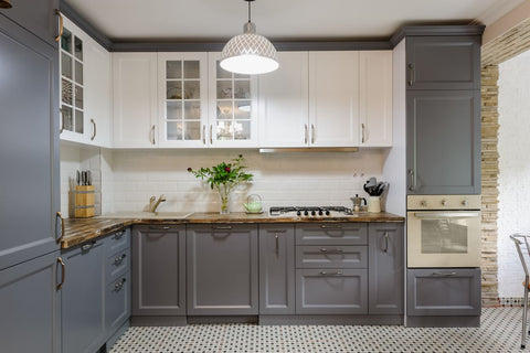 A two-tone shaker style kitchen with glass panel cabinet doors. 