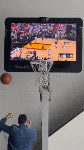 Basketball Player Going for a Layup While Watching a Live Game