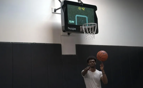 A player holding a basketball and pointing at camera.