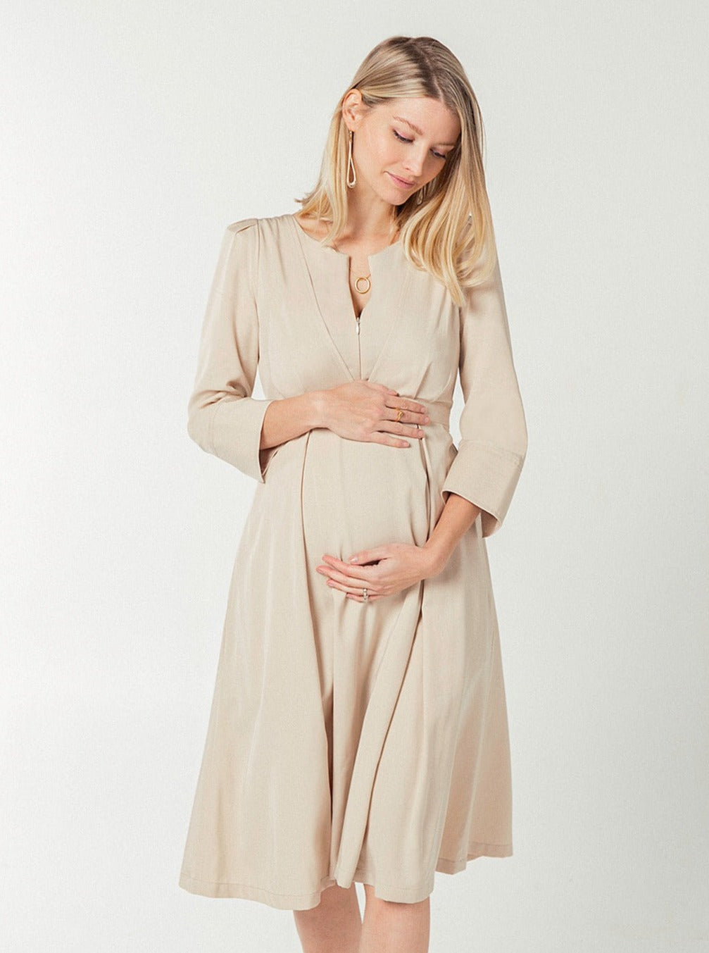 TENCEL maternity dress with empire waist, zipper nursing access, and full skirt with pockets. Beige.