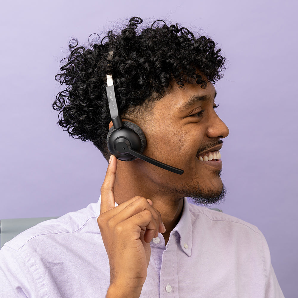 Man wearing GO Work Pop Wireless On-Ear Headset and reaching for controls on earcup