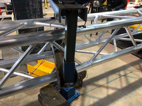 Lighting truss with a visible crack near the center cross weld.