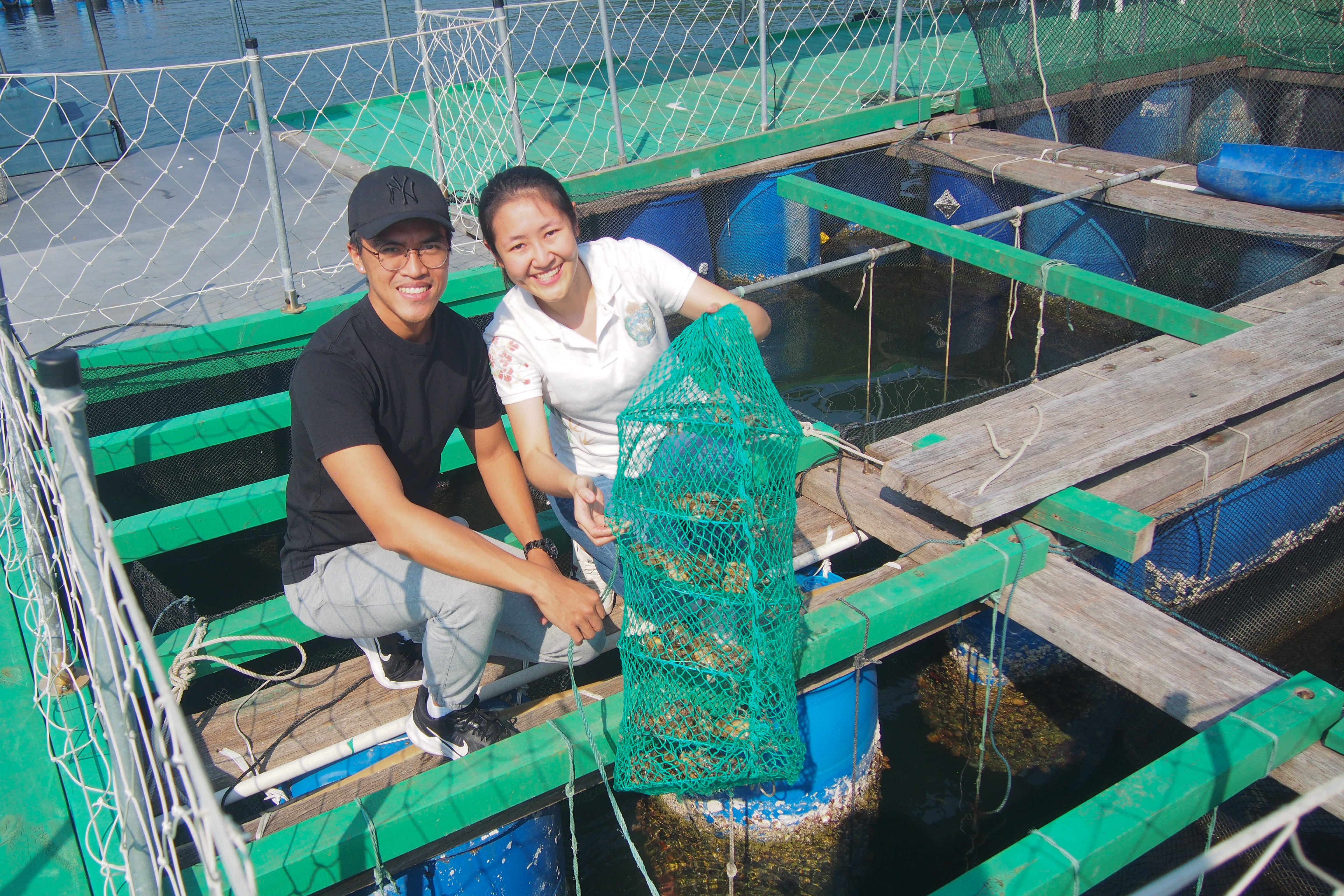 Woody, a staff member at Sai Kung Sham Wan Fish Steak Farm, took Alicia, co-founder of Mer-Veille, to try to lift the cage used for cultured pearl oysters from the water to learn more about pearl farming.