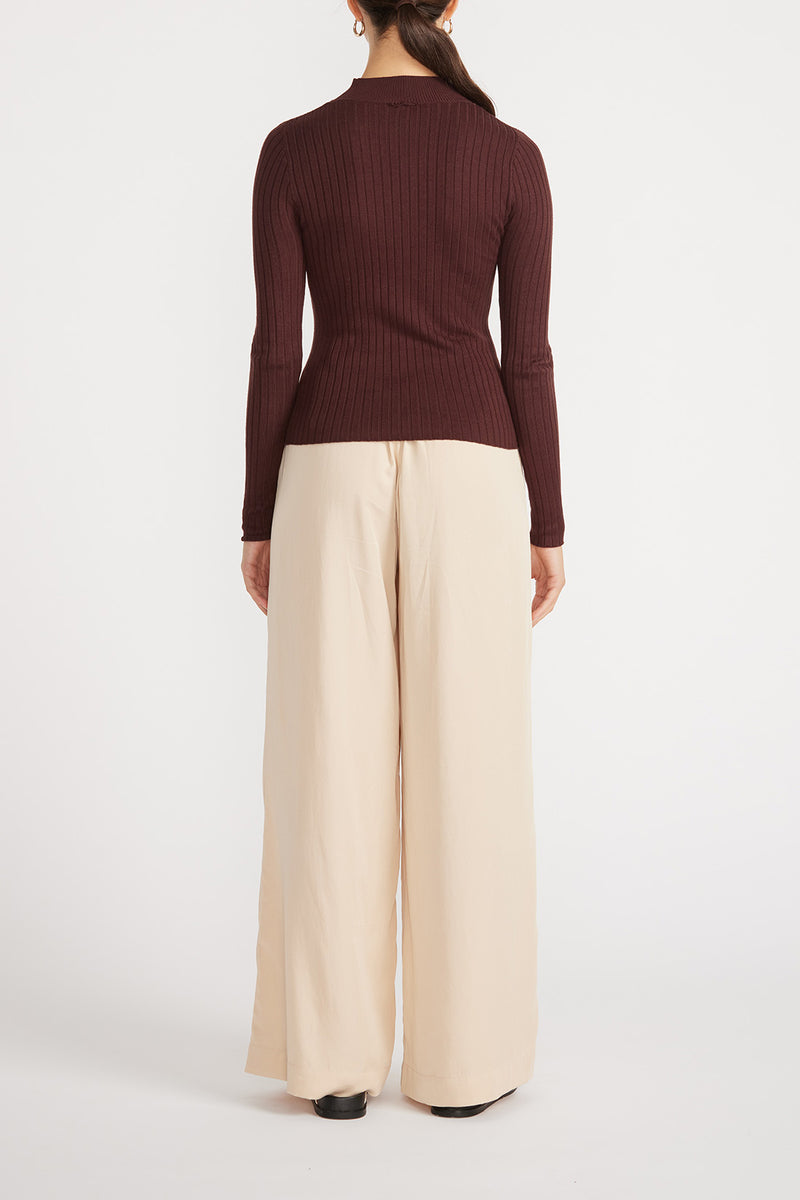 Rear view of woman wearing Kaia Knit Skivvy with wide leg pants.