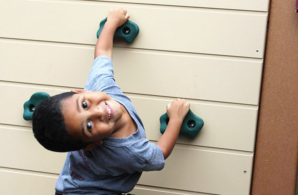 Child Climbing On Rock Wall