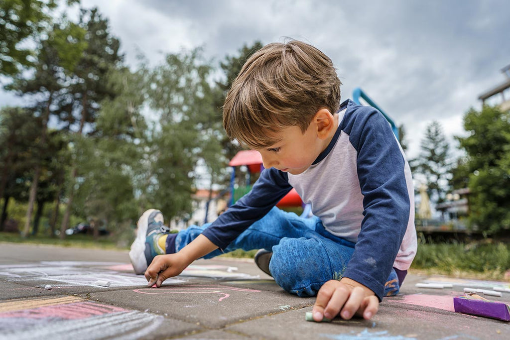 Child Drawing With Chalk Outdoors