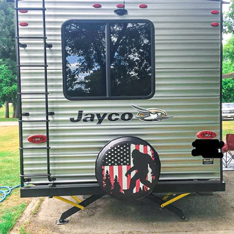 Jayco RB hauler with a sasquatch bigfoot spare tire cover that has an american flag in the background and bigfoot silhouette walking in front of it.