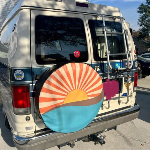 Vintage retro sunrays and ocean waves spare tire cover for a conversion van.