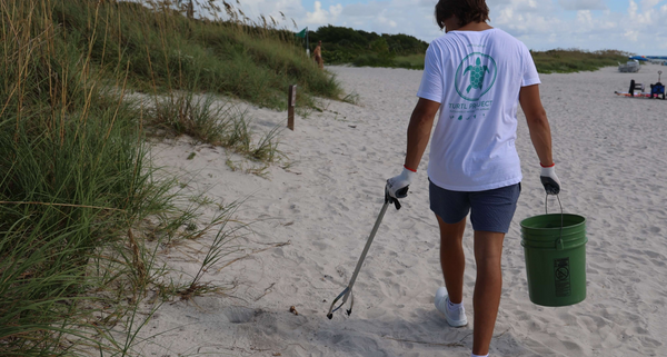 man picking up trash in beach cleanup