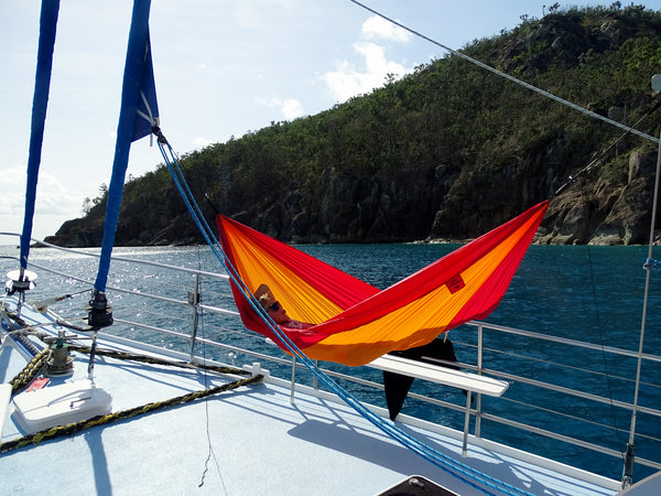 Man using an Ultra-light adventure hammock on a boat