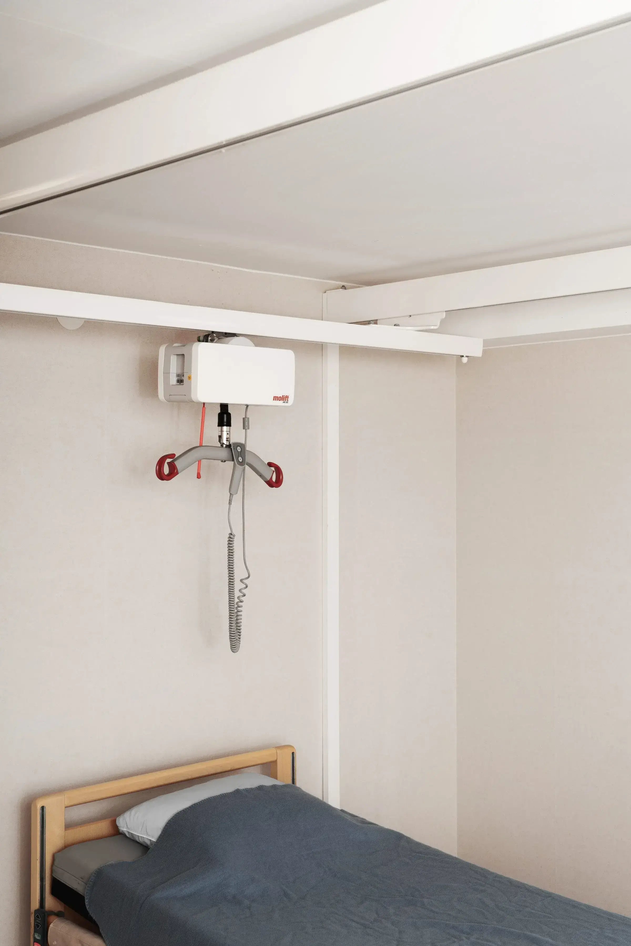 molift air 205 hanging above a bed on a rail system