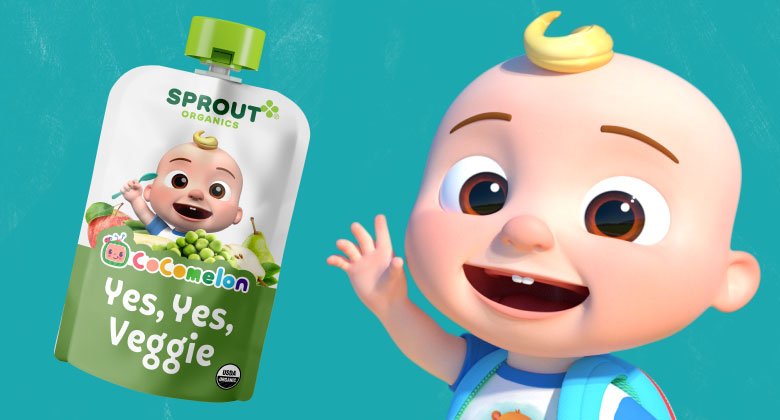 CoComelon star JJ smiles while holding Sprout Organics CoComelon Yes, Yes, Veggie food pouch.