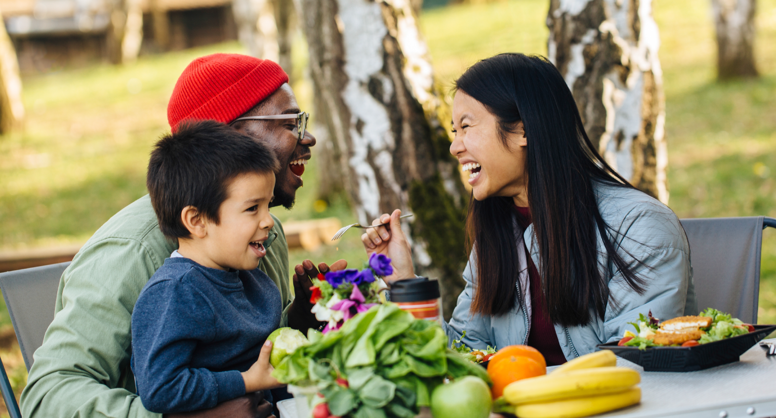 a family has fun at an outdoor table with fresh produce