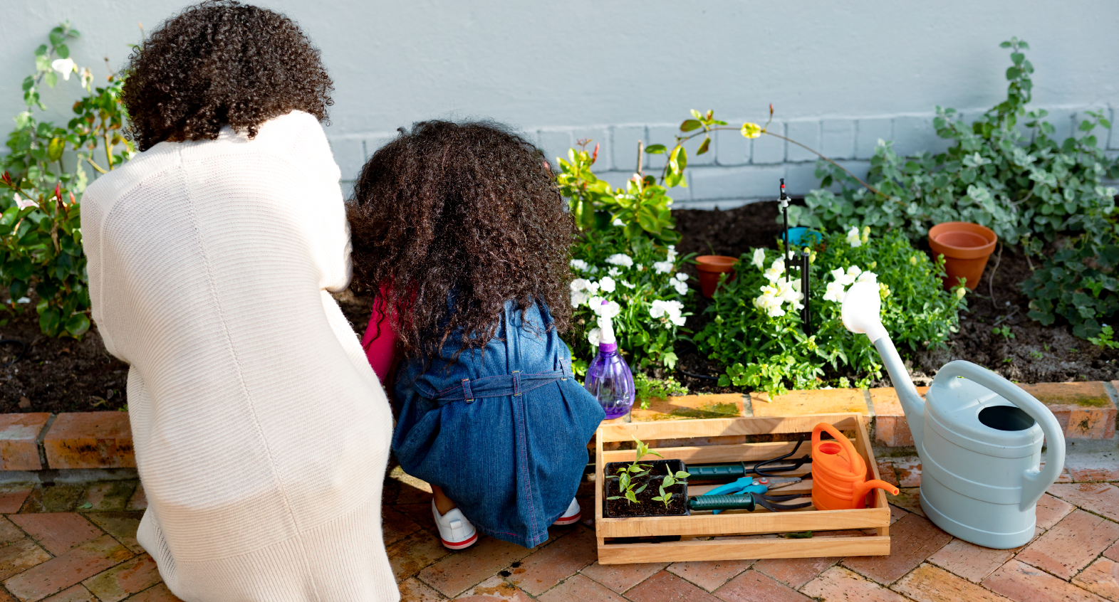 A child and parent next to a small garden space