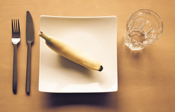 Assiette blanche avec un banane au centre